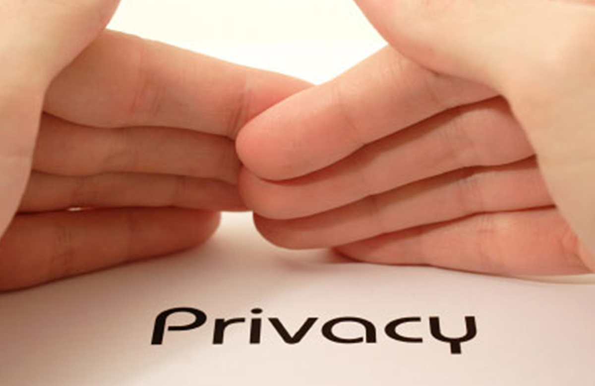 Hands Covering the Word ‘Privacy’ on Paper